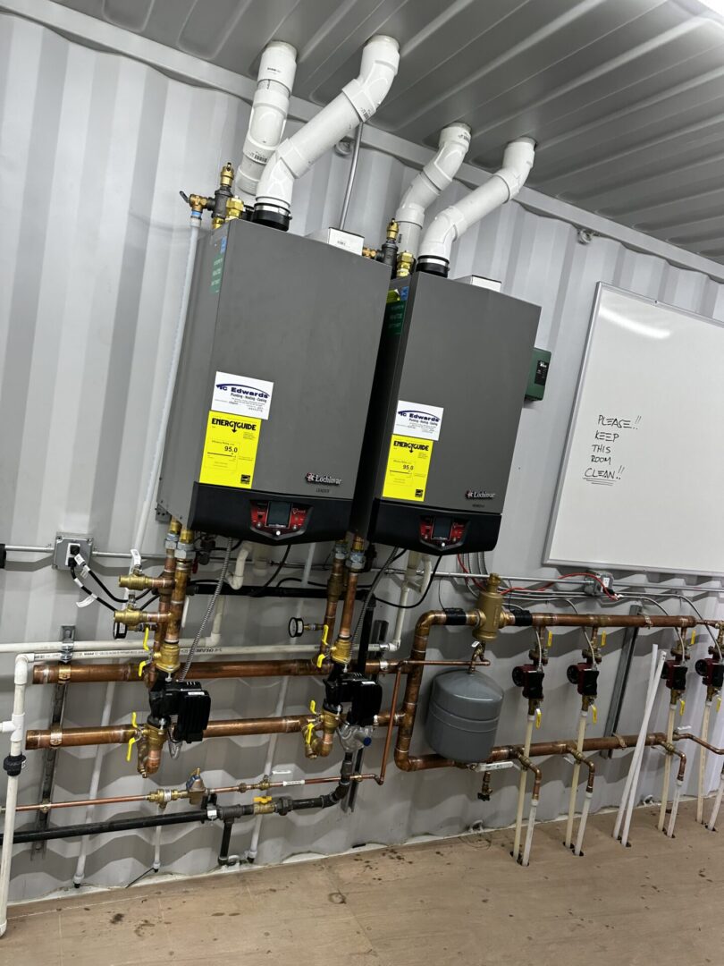 Two wall-mounted tankless water heaters with piping