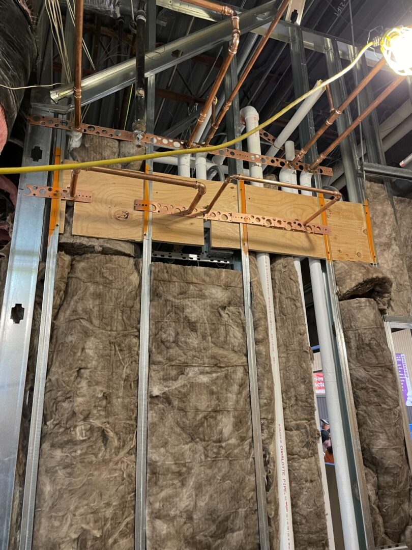 Construction wall with pipes, insulation, metal studs